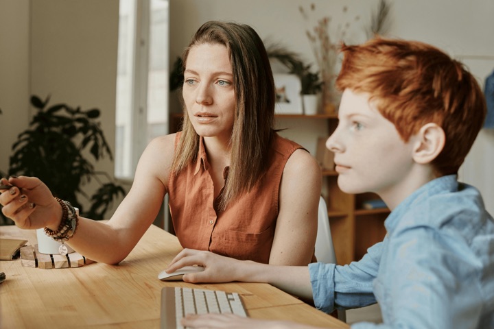 Schulbegleiterin unterstützt ein Kind beim Lernen